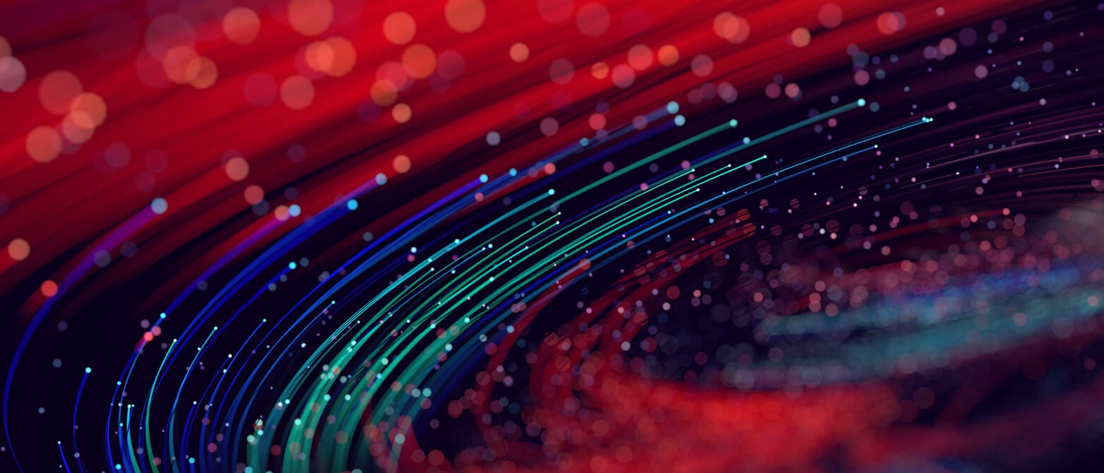 Colorful digital image of curved lines and light dots, creating a visual effect of a dynamic wave in shades of blue and red.