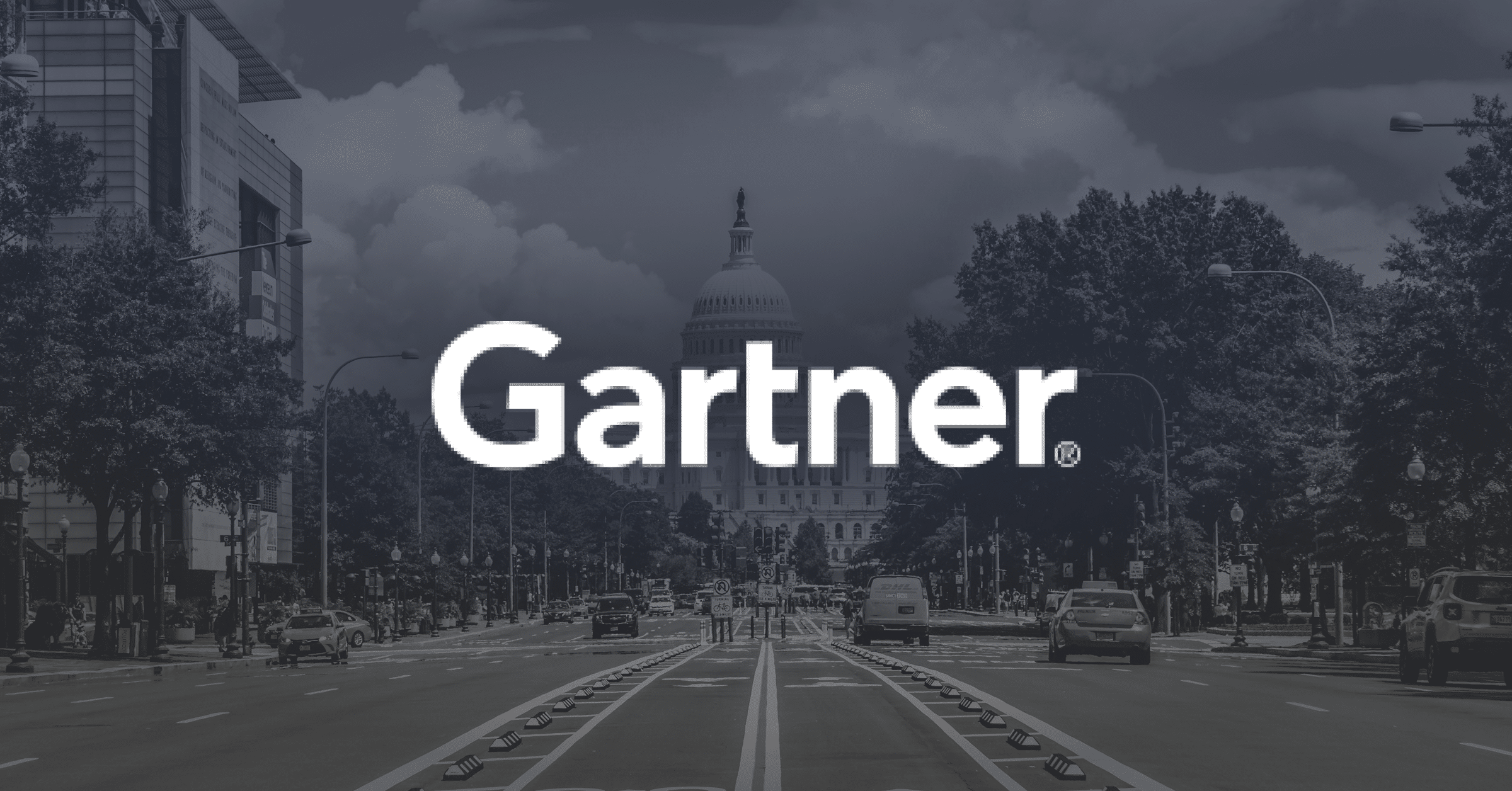 A city street view with cars and trees on both sides, leading toward a domed government building in the background. The word "Gartner" is prominently displayed in large white letters across the center.