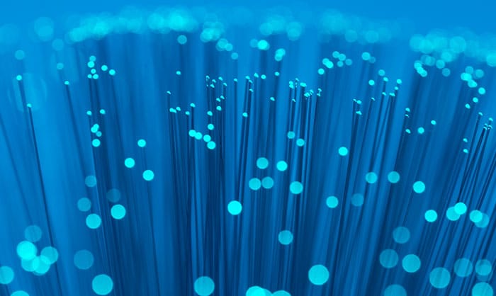 Close-up view of blue fiber optic cables with illuminated ends, representing high-speed data transmission technology in a security operations newsletter.