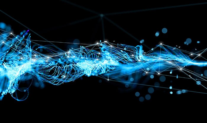 Dynamic digital representation of blue glowing particles interconnected by lines, creating a wave-like pattern on a dark background, symbolizing network connectivity or data flow.