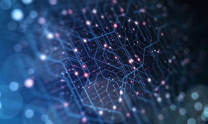 Abstract image of a neural network with interconnected nodes and pathways highlighted by glowing dots and lines on a dark, blurred background.