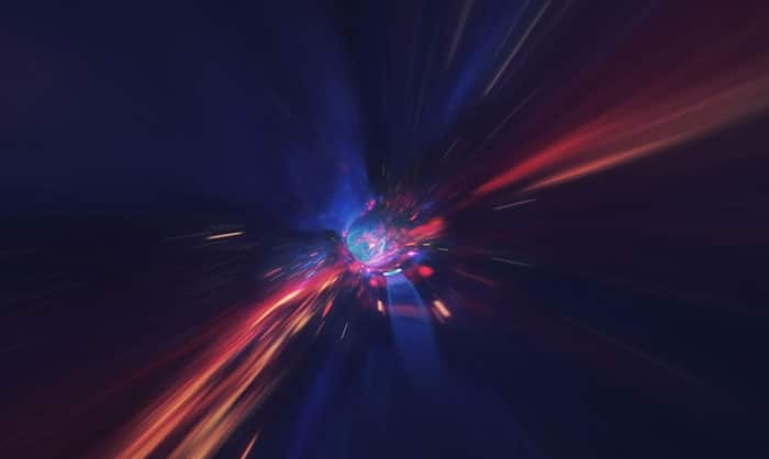 Abstract image depicting a burst of blue and red light rays emanating from a central bright source, creating a sense of high-speed motion or energy explosion in a dark space, symbolizing the dynamic nature of