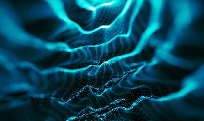 Abstract digital image depicting waves of blue light forming dynamic, flowing lines on a dark background, suggestive of navigating the world of AI and data or energy movement.